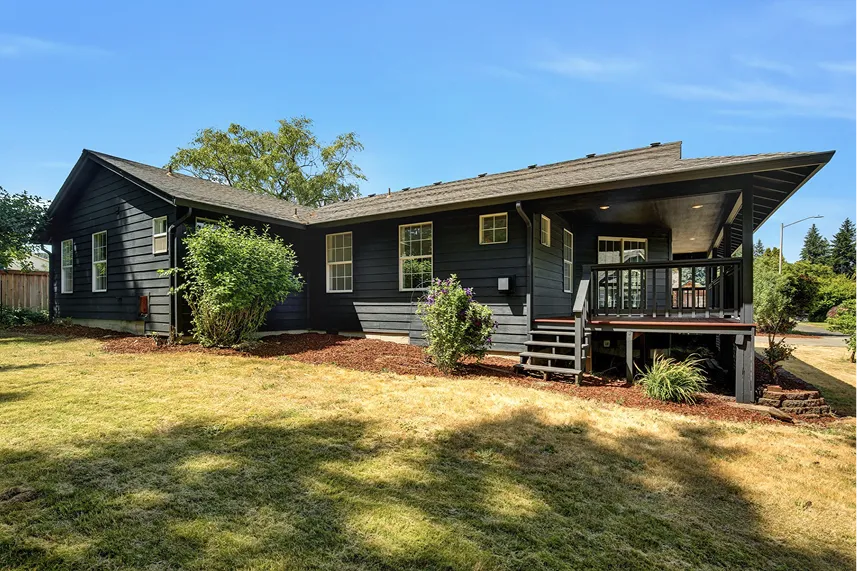 Black house with porch and landscaped yard, representing Portland Cash Buyers' commitment to buying homes as-is for cash offers.