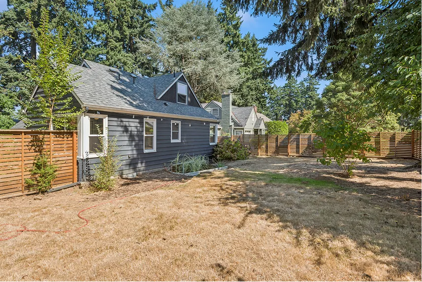 House with gray exterior and fenced yard in Portland, showcasing a low-maintenance property ideal for cash buyers.